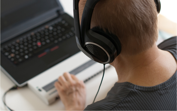 Person using a braille reading device on a computer