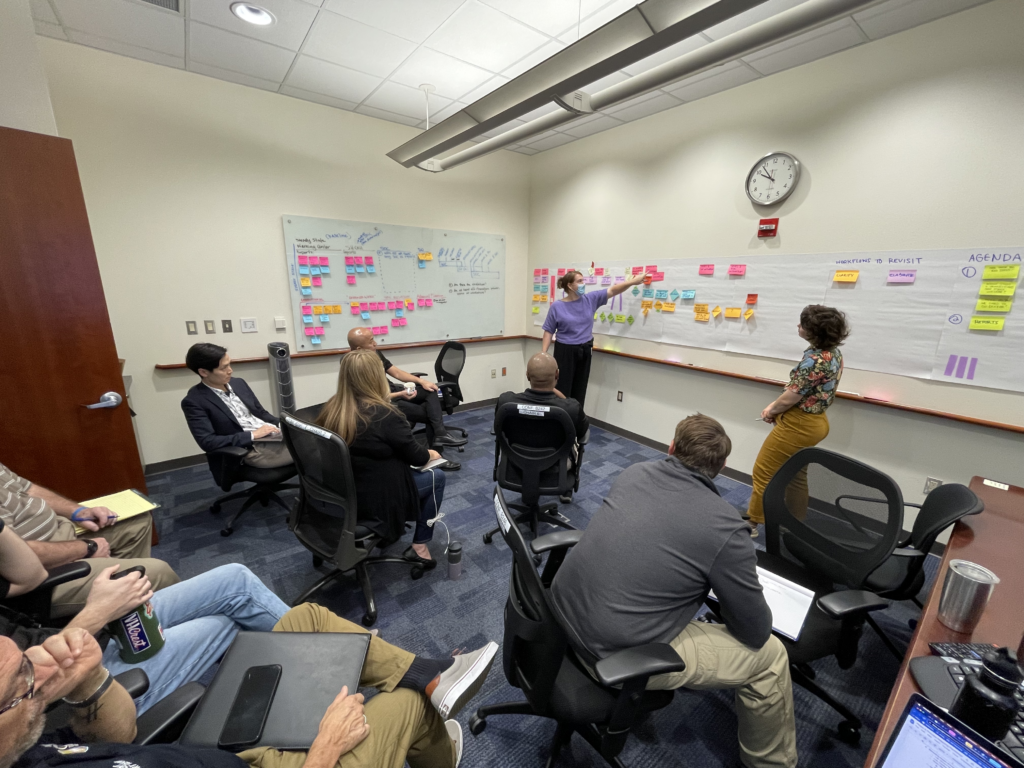State staff mapping a process using sticky notes on a wall