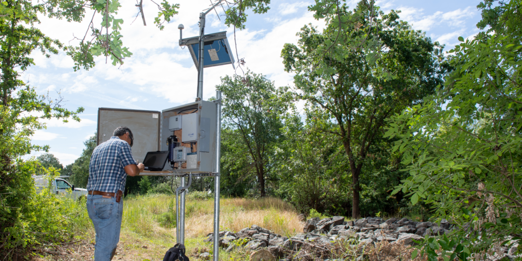 A technician checks water levels at a monitoring station