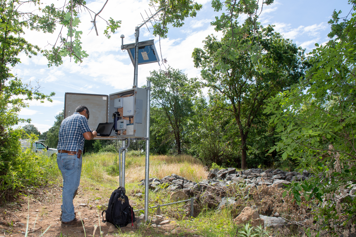 A technician checks water levels at a monitoring station
