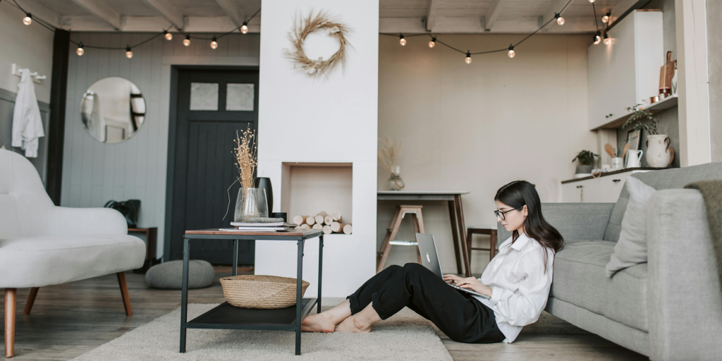 A woman in her living room typing on a laptop
